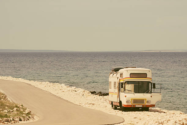 retro van pelo mar no velho estilo de fotografia - personal land vehicle fotos imagens e fotografias de stock