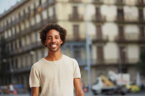 Portrait of young man smiling against building