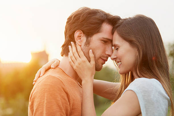 couple embracing in park - love romance couple sensuality zdjęcia i obrazy z banku zdjęć