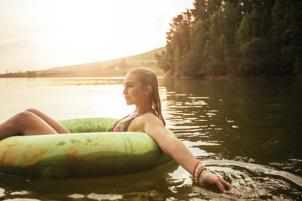 istock Young woman in lake on inflatable ring 509408206