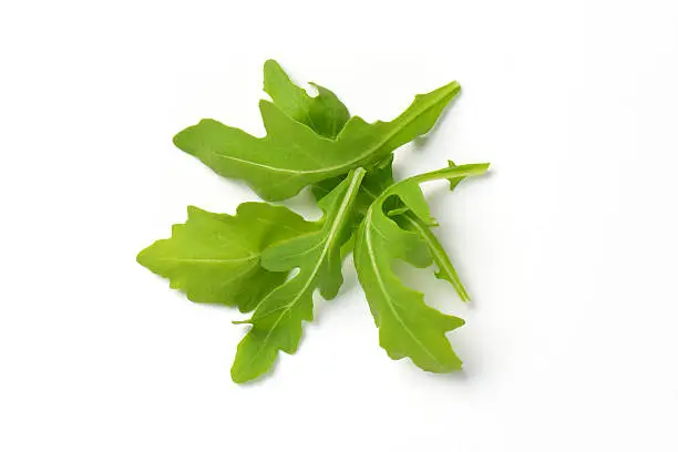 handful of fresh arugula leaves on white background