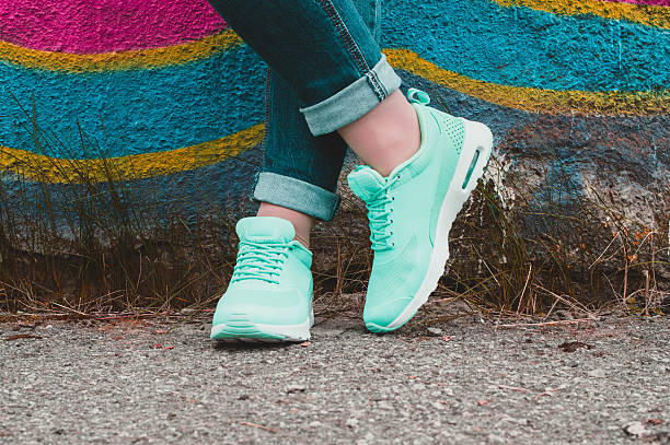 istock Peppermint sneakers on girl legs on the graffiti background 509408344