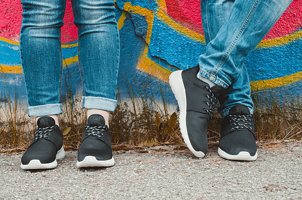 istock Black sneakers on couple's legs on the graffiti background 509408558