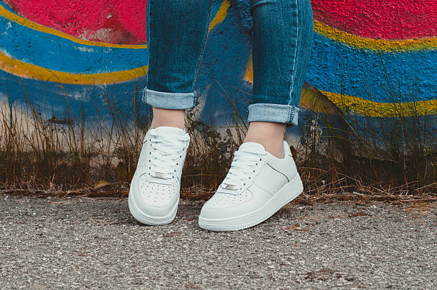 istock White sneakers on girl legs on the graffiti background 509408872