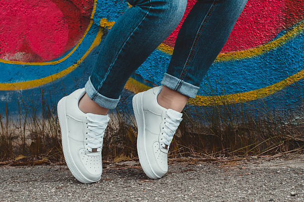istock White sneakers on girl legs on the graffiti background 509409024