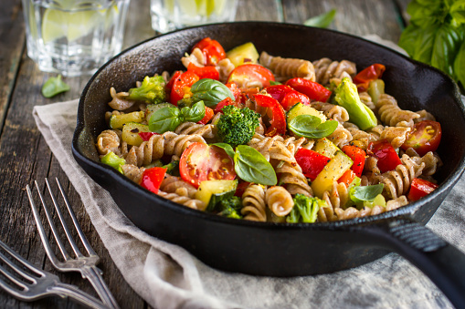 Whole wheat pasta  with vegetables on cast iron pan