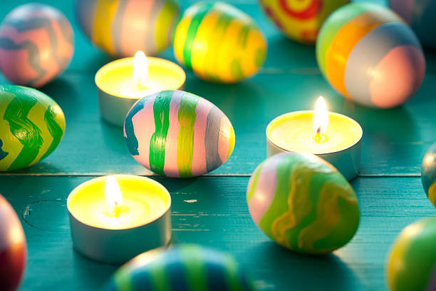 Colorful easter eggs and candle on turquoise wooden table. This file is cleaned and retouched.