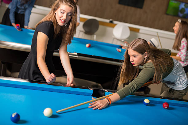 istock Young friends playing pool or billiard 509414630