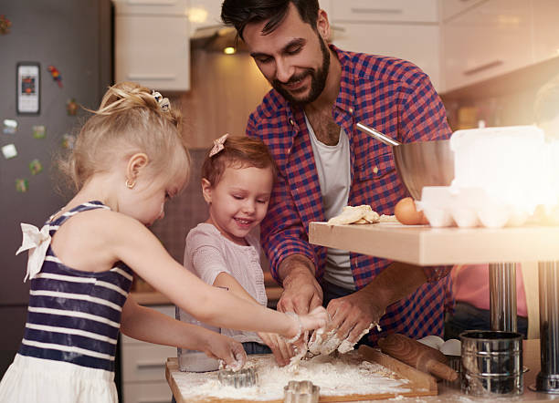 istock Father and little daughters having fun in the kitchen 509414836