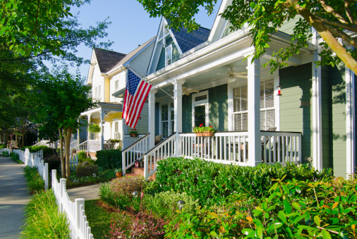 The American Dream of a house in a nice neighborhood with a white picket fence is captured in this iconic image.