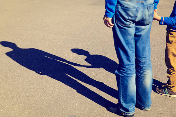 istock Shadows of father and son holding hands 509418100
