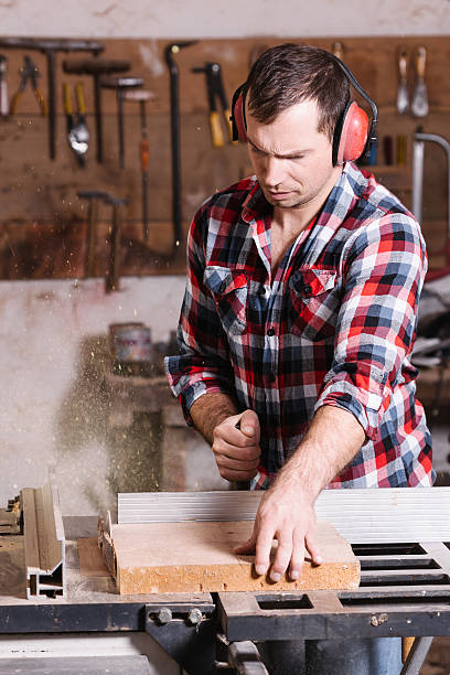 istock Carpenter working on an electric buzz saw cutting some boards 509419024