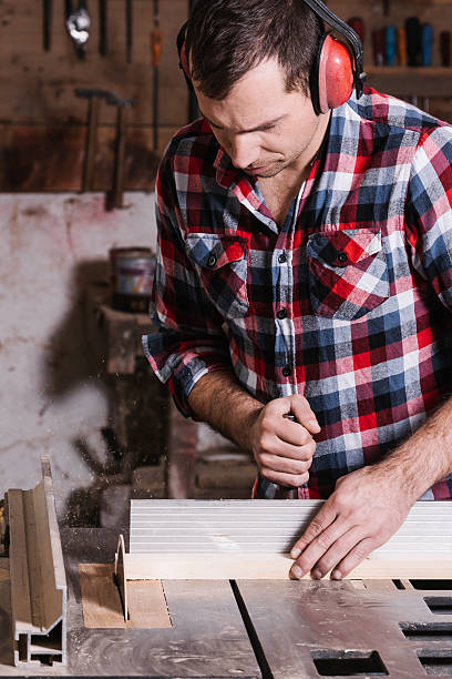 istock Carpenter working on an electric buzz saw cutting some boards 509419878