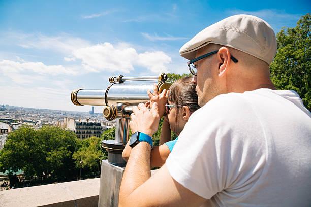 istock Father and daughter using a telescope in Paris 509420250