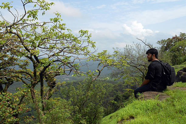 istock man sitting on the edge of mountain 509421338