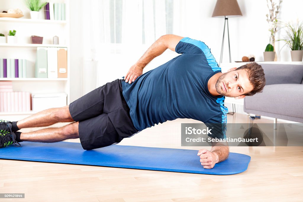 Gesunde Mann tun Seite Plank Übung auf Matte - Lizenzfrei Bauholz-Brett Stock-Foto Gesunde Mann tun Seite Plank Übung auf Matte - Lizenzfrei Bauholz-Brett Stock-Foto