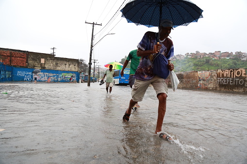 Salvador, Brazil - May 10, 2015: Man is seen walking in flooded street after a thunderstorm in the Uruguay neighborhood in Salvador (BA).