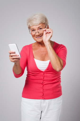 Senior woman using contemporary smartphone