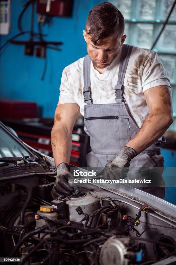 Mechanic servicing car Mechanist is disassembling car parts using monkey wrench Adult Stock Photo