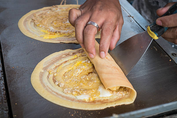 Seller rolling Khanom Tokyo Thai street snack