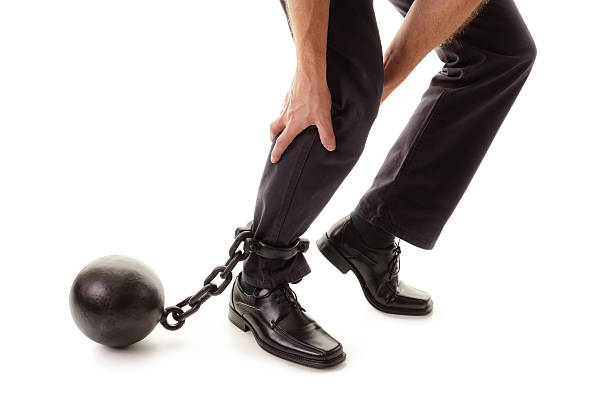 Ball and chain Ball and chain restraining a businessman as he tries to walk concept for business burden, willpower and determination dragging photos stock pictures, royalty-free photos & images