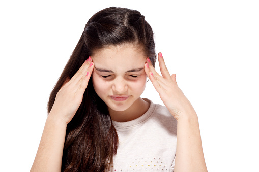 Teenage girl in pain holding her head