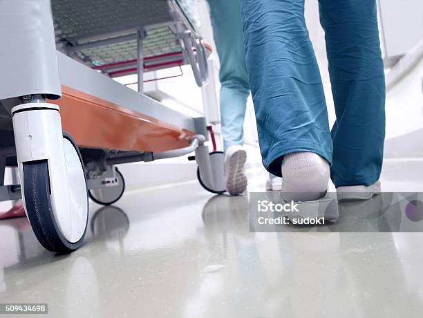 Medical Staff Moving Patient Through Hospital Corridor Stock Photo - Download Image Now