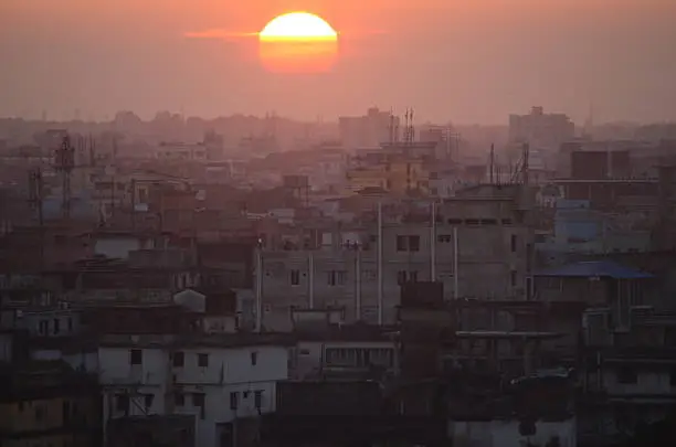 The sun is setting over the smoggy city Dhaka