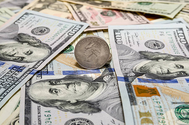 istock Quarter dollar coin and One  Hundred Dollar banknotes currency 509436350
