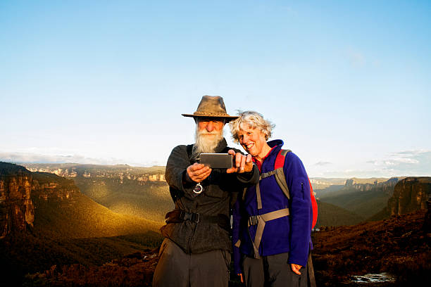 Senior Couple taking Selfie Senior couple holding up an mobile phone taking a selfie. Australia outback, Blue Mountains National Park. blue mountains australia photos stock pictures, royalty-free photos & images
