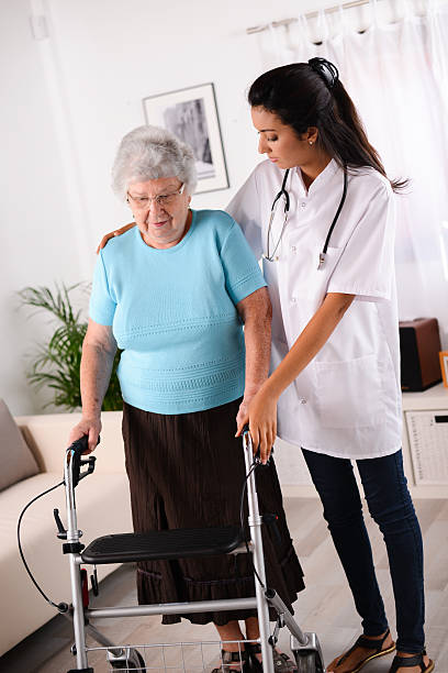 istock cheerful young rehab nurse helping elderly woman using walker 509447813
