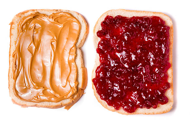 Open Face Peanut Butter and Jelly Sandwich Simple peanut butter and jelly sandwich with strawberry jam and chunky peanut butter on white bread, separated and placed on a bamboo cutting board with soft natural window light. peanut butter and jelly sandwich stock pictures, royalty-free photos & images