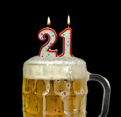 Birthday candles in beer mug for 21st birthday isolated on black.