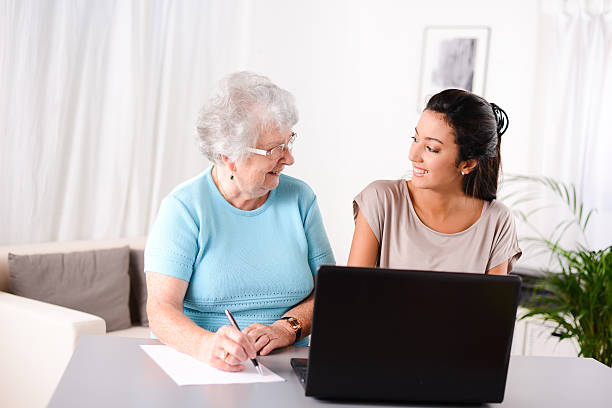 istock young woman helping elderly person with computer internet search email 509466123