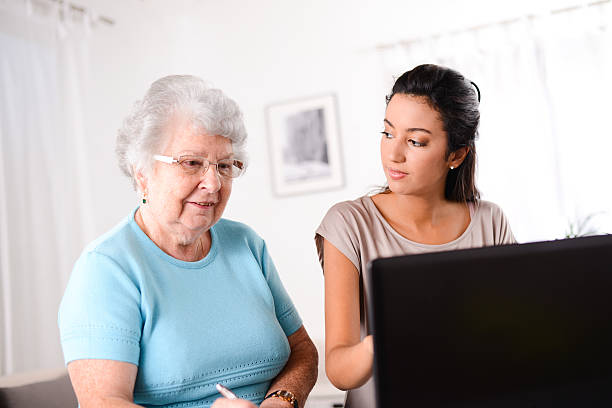 istock young woman helping elderly person with computer internet search email 509466653