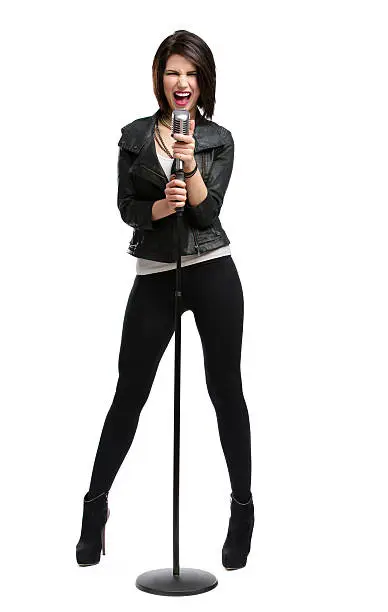 Full-length portrait of rock singer wearing leather jacket and keeping static mic, isolated on white. Concept of rock music and rave