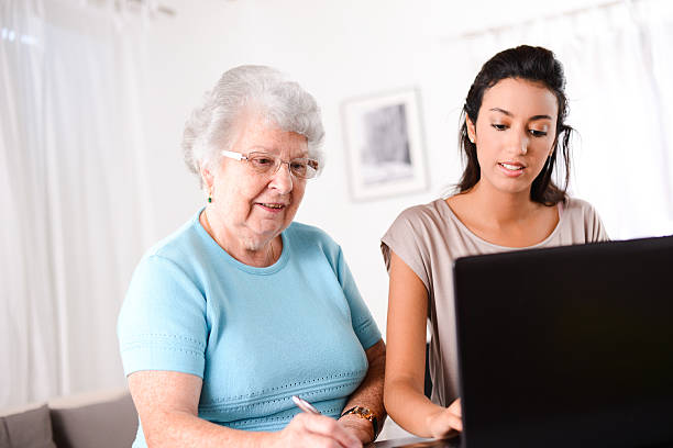 istock young woman helping elderly person with computer internet search email 509466913