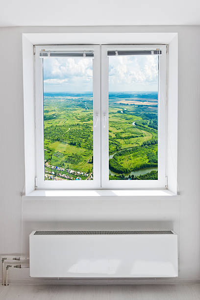 istock White plastic double door window with radiator under it. 509469263