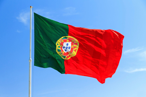 Beautiful large Portuguese flag waving in the wind against a blue background in Lisbon, Portugal