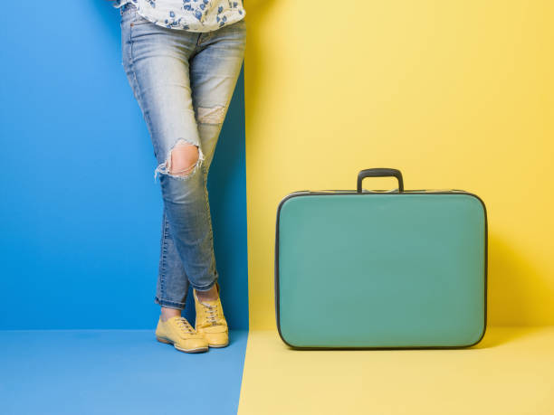 istock Woman stands beside suitcase 509469804