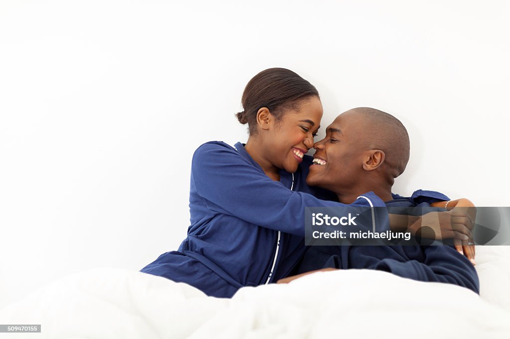 Afroamericano par abrazar en la cama - Foto de stock de Abrazar libre de derechos