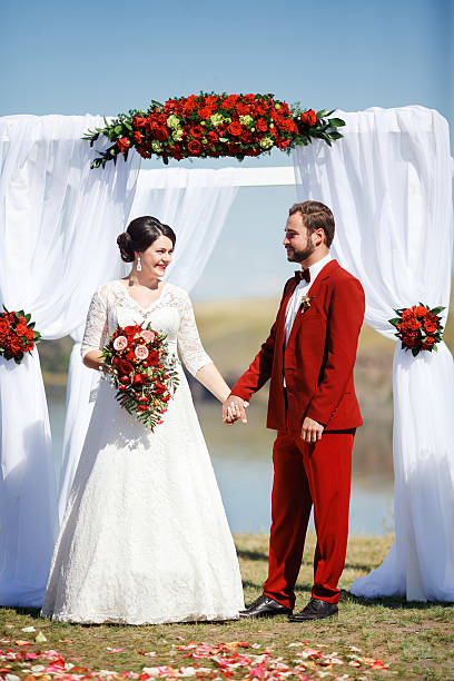 Bride and groom during wedding ceremon, arch flowers outdoors stock photo