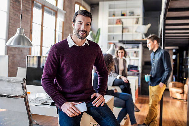 istock Businessman smiling with mobile phone sitting on his desk 509475268