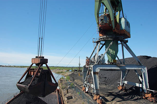 istock Crane loading coal to ship at Kolyma river port 509475522