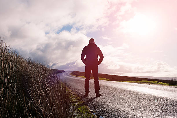 istock Man stood on an open Country road 509478028