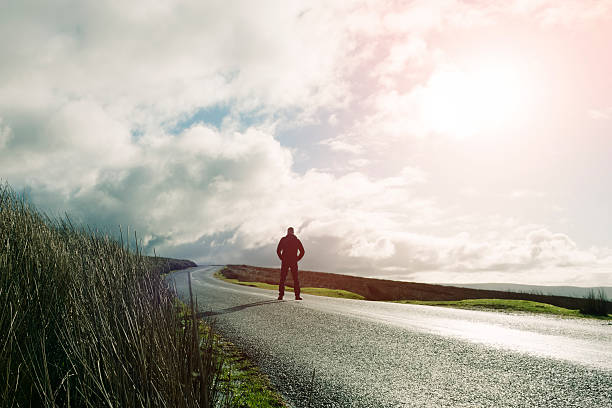 istock Man stood an open Country road 509478410