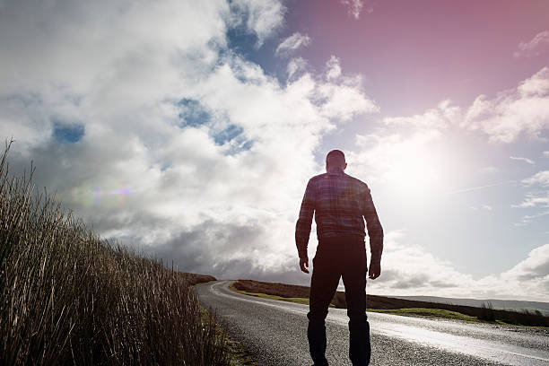 istock Man walking along an open Country road 509478796