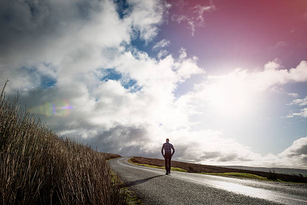 istock Man walking along an open Country road 509479156