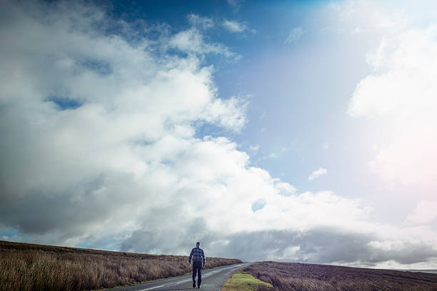 istock Man walking along an open Country road 509479668