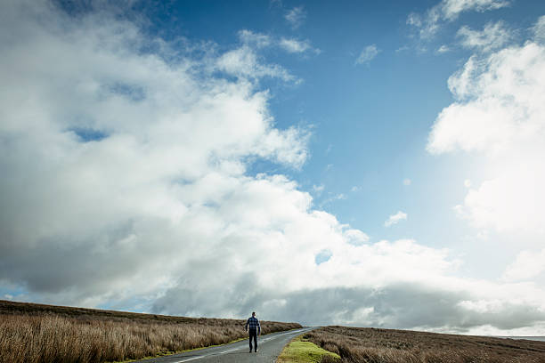 istock Man walking along an open Country road 509479844